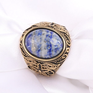 Vue macro d'une bague vintage dorée ornée de lapis-lazuli bleu et gravures fines