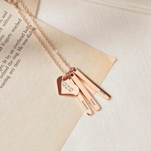 Détail du collier en or rose avec cœur gravé et pendentifs barres personnalisés