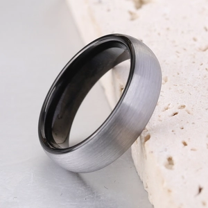 Detail eines gebogenen Edelstahlrings mit gebürsteter Außenseite und schwarzem Innenband