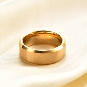 Macro view of golden tungsten carbide ring showing brushed surface and polished edges