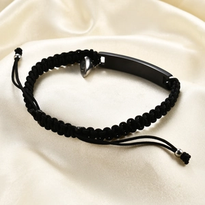 Detail of adjustable black braided couple bracelet with magnetic clasp and metal plate