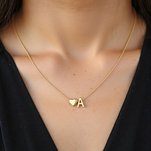 Minimalist gold necklace with 3D heart and initial A pendant on a model