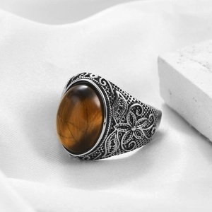 Dettaglio macro di un anello retrò in acciaio inossidabile con occhio di tigre e rilievi