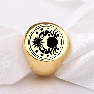 Detaillierte Makroansicht des goldenen Edelstahlrings mit lasergraviertem Krebs-Sternzeichen