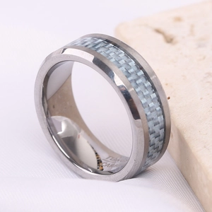 Dettaglio macro dell'anello in tungsteno con intarsio in fibra di carbonio blu e incisione