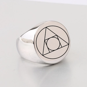 Macro shot of silver stainless steel signet ring with engraved geometric alchemy symbol