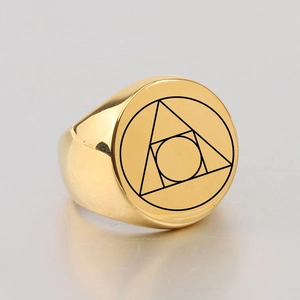 Macro shot of gold signet ring featuring circular geometric alchemy symbol engraving