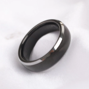 Close-up of brushed black stainless steel ring with polished edges on white silk