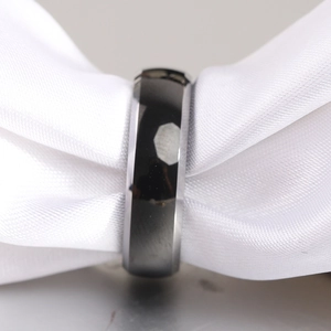 Macro shot of a high-polished beveled edge men's ring on a luxury white satin ribbon