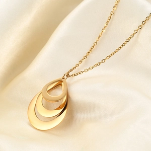 Elegant gold triple teardrop pendant necklace for women on white silk background
