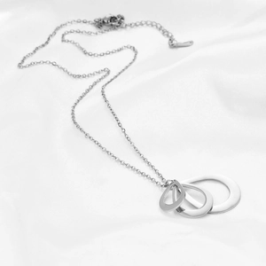 Detailed view of silver nested teardrop pendant on elegant white silk background