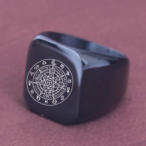 Macro detail of black stainless steel signet ring with engraved zodiac astrology symbols
