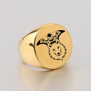 Macro detail of gold signet ring featuring laser-engraved hawk and wolf totem patterns