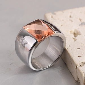 Détail macro d'une bague cristal ambre 14mm avec un large anneau en acier inoxydable poli