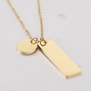 Primer plano de collar minimalista de acero dorado con colgantes redondos y rectangulares