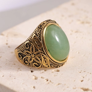 Détail macro de la bague en acier de 22mm avec pierre verte et gravure florale