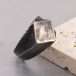 Close-up of vintage geometric rhombus ring with distressed industrial metal finish
