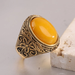 Vue macro d'une bague dorée vintage gravée de fleurs avec une grande ambre