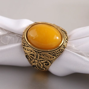 Gros plan sur bague vintage avec pierre ambre et gravures florales sur ruban de soie