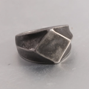 Macro detail of geometric faceted stainless steel ring with a vintage matte finish