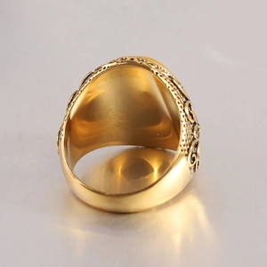 Détail d'une bague dorée vintage avec motifs en relief complexes et gravures ajourées