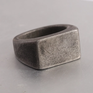 Macro shot of industrial vintage stainless steel signet ring with brushed metal texture