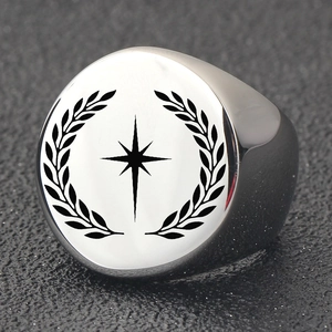 Macro detail of men's round signet ring with engraved star and laurel leaves pattern