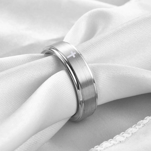 Dettaglio anello in acciaio spazzolato da 6 mm con simbolo a croce laser su raso bianco