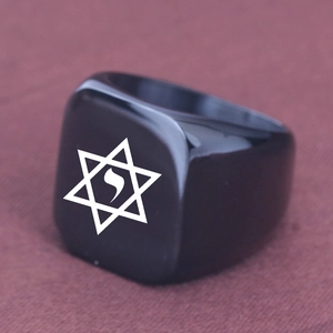 Close-up of black hexagram signet ring with white laser engraved star on fabric background
