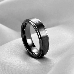Dettaglio di un anello da 6 mm in tungsteno nero spazzolato con motivo a croce laserato