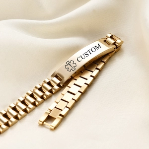 Detailed view of custom engraved gold medical alert bracelet on silk fabric background