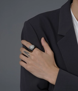 Detail view of a black stainless steel signet ring featuring a silver Vegvisir Viking compass