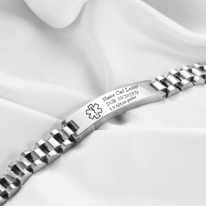 Close-up of a stainless steel medical alert bracelet with red cross logo on silk