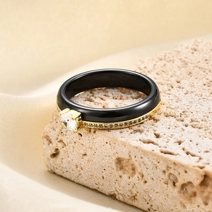Macro shot of 4mm black ceramic ring with gold plating and paved zircon stones detail
