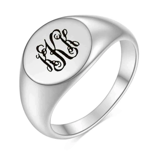 Detalle de un anillo de sello plateado con letras KR grabadas con láser en cursiva