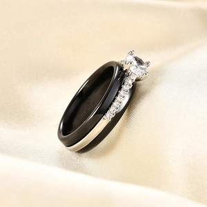 Detail van een zwarte keramische ring met 6mm zirkoon op een luxe champagne zijden stoffen
