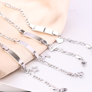 Detail von silbernen Figaro-Armbändern mit ID-Platten und Herz- oder Kronenanhängern