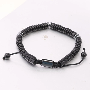 Close-up of woven bead bracelet with tiger eye stones and adjustable black cord