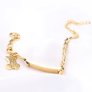 Goldenes Edelstahl-Armband mit poliertem Balken und Bären-Anhänger auf weißer Seide