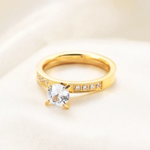 Macro shot of 3mm gold-plated cubic zirconia ring on soft satin fabric background