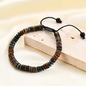 Detailed macro view of adjustable natural stone bead bracelet on a textured stone prop