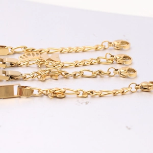 Detailliertes Set aus vier polierten 6mm Gold-Edelstahlarmbändern mit Anhängern und Gravurplatten