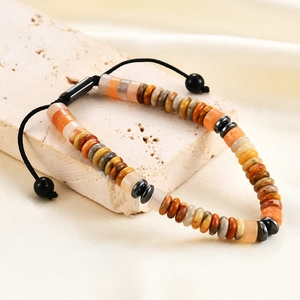 Detail view of adjustable tiger eye and obsidian beaded bracelet on stone stand