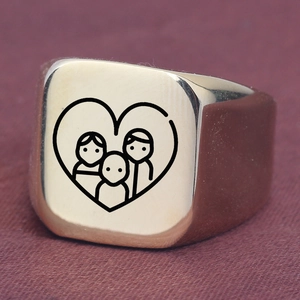 Macro shot of gold square signet ring with family and heart engraved pattern