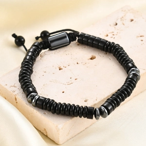 Macro view of adjustable tiger eye and black stone beaded bracelet with silk and stone decor