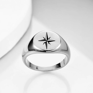 Macro detail of silver stainless steel signet ring with black octagram star engraving