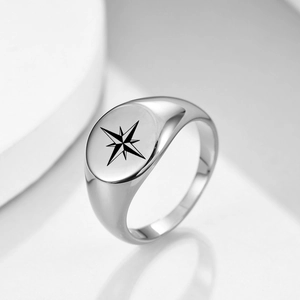 Macro shot of silver stainless steel signet ring with engraved black octagonal star