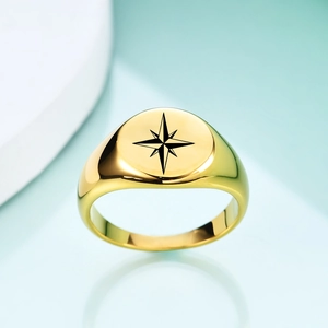 Macro shot of gold stainless steel signet ring with black laser octagram star pattern