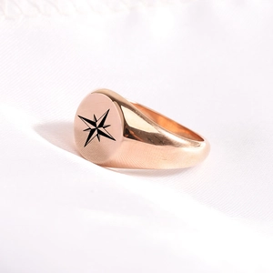Macro detail of vintage gold octagonal star engraving on a round stainless steel ring surface