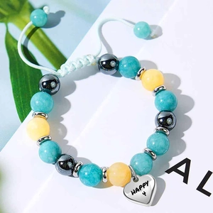 Dettaglio del bracciale regolabile con cuore e perle di turchese, ambra ed ematite